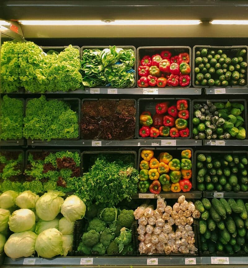 Shelves of lettuce, peppers and cucumbers in a greengrocer's